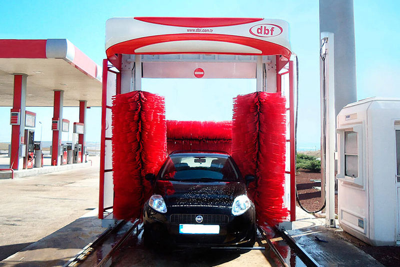 A car going through an automatic car wash outside.